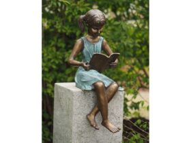 Figura de bronce. Niña leyendo. 64 x 30 x 29 cm.