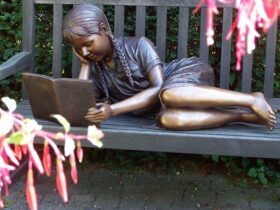 Figura de bronce. Niña leyendo. 43 x 43 x 92 cm.