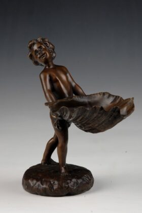 Figura bronce. Niño con concha. 14 x 17 x 20 cm.