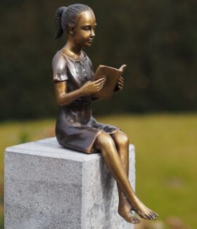 Figura en bronce. Niña leyendo. 22 x 11 x 7 cm.