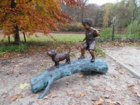 Figura en bronce. Niño con perro en árbol. 107 x 69 x 150 cm.