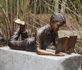 Figura en bronce. Niño leyendo. 35x25x75cm.